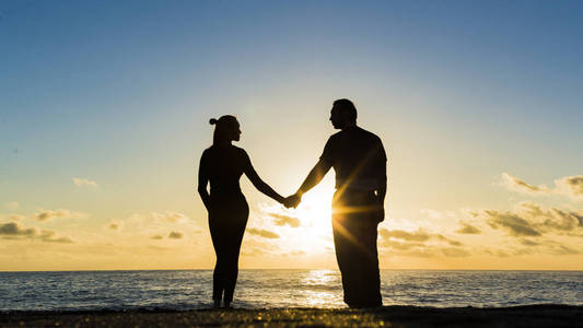 海上的日落.两个映衬在阳光下.刚刚结婚的夫妇拥抱.浪漫的爱情故事.