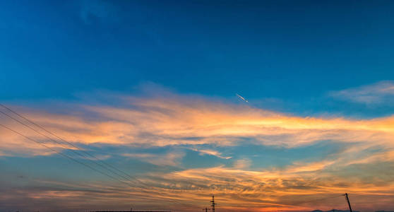 黄昏蓬松黄昏的草地. 日落背景,五颜六色的天空和蓬松的云彩.照片