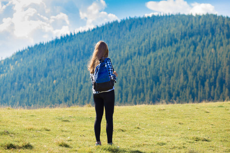 后景年轻女子背着背包在山顶寻找自然山谷