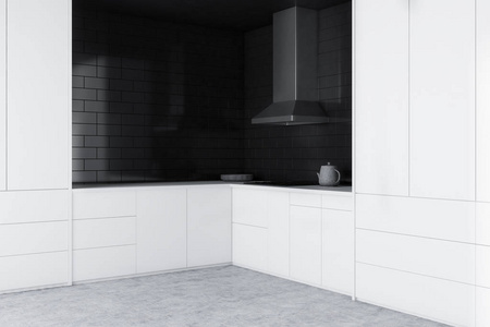 带有黑色砖墙混凝土地板白色台面橱柜和炊具的极简厨房角落。3D渲染