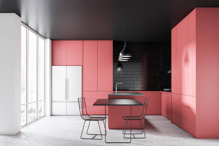 现代厨房内部有黑色砖墙，混凝土地板，黑色天花板，粉红色台面和橱柜，冰箱，灰色和粉红色岛和黑色桌子与椅子。3D渲染