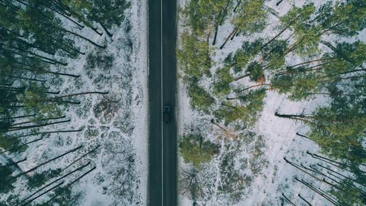 用道路鸟瞰雪林。 从上面用无人驾驶飞机捕获