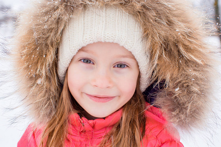 在阳光明媚的冬日雪小可爱女孩的肖像