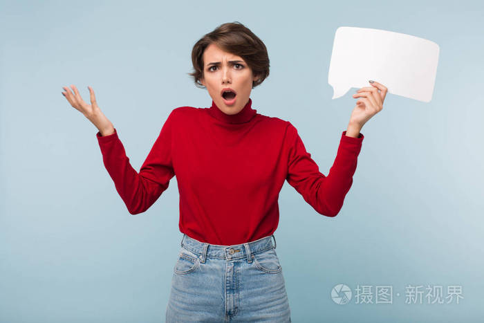 年轻的惊讶女人一头黑发穿着红色毛衣悲伤地看着镜头手里拿着白纸形状