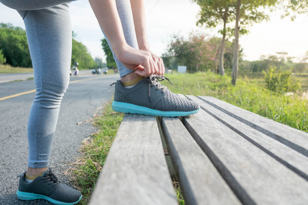 运动的女人在练习前把鞋带系在跑鞋上