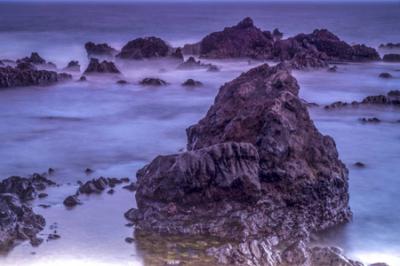 长曝光雾效应海洋背景的岩石自然照片