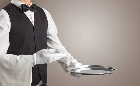 服务员用白色手套和钢托盘服务照片