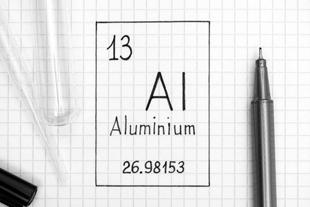 元素的周期表。 手写化学元素铝与黑色笔试管和吸管。 快关门。