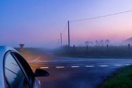 法国诺曼底，一个雾蒙蒙的夜晚，汽车停在奥恩乡村的十字路口