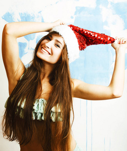 年轻漂亮的女人微笑着快乐的红色圣诞老人帽子在新年, 我