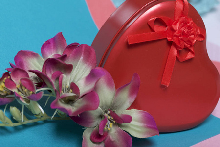 带礼物的红心形盒子..接下来是一朵花。在一张五彩纸的背景上..