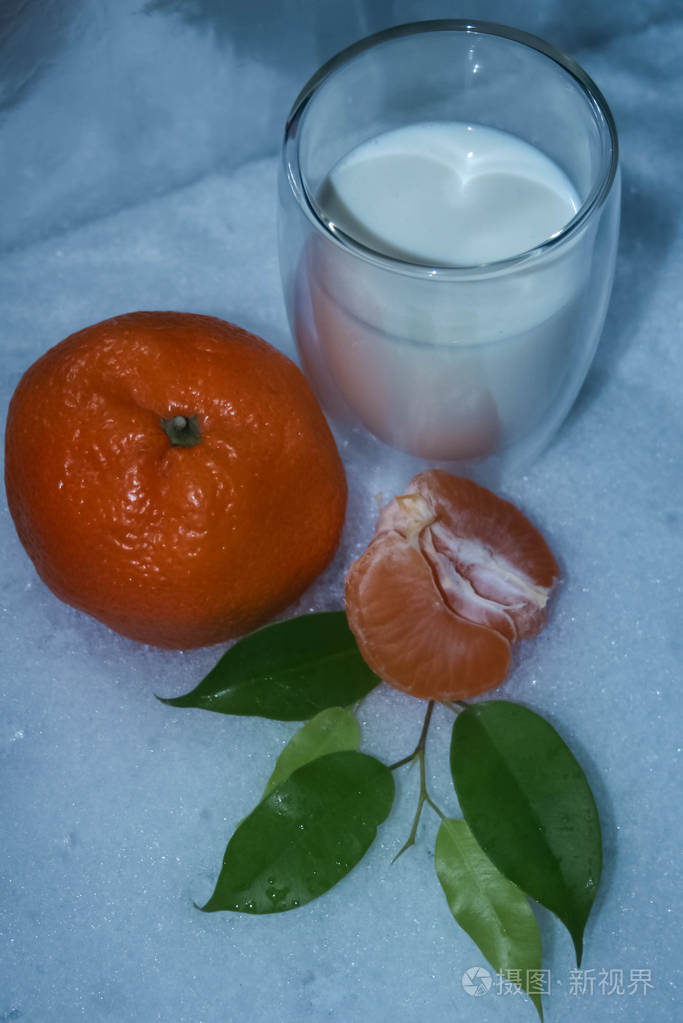 一杯牛奶加橘子和绿叶