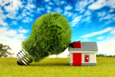 绿色环保灯泡和微型房子. 可再生能源概念. 家庭节能的电价.照片