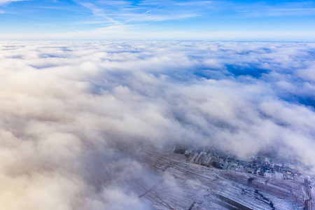 厚厚的空中云景。 乘飞机旅行。 郊区白雪覆盖