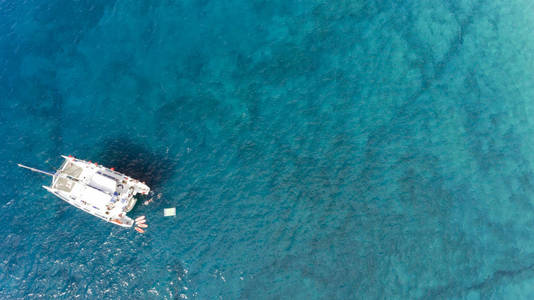 双体船在清澈的绿松石海水上的俯视.照片