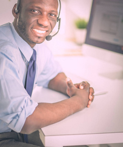 非洲裔美国商人对耳机工作在他的笔记本电脑