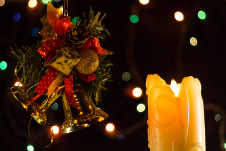 圣诞蜡烛在燃烧。 靠近云杉和铃铛的绿色树枝
