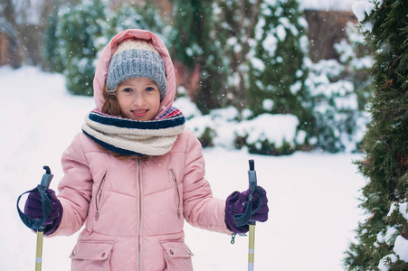 快乐的女孩滑雪在冬天的雪林度假户外。 积极的冬季运动。