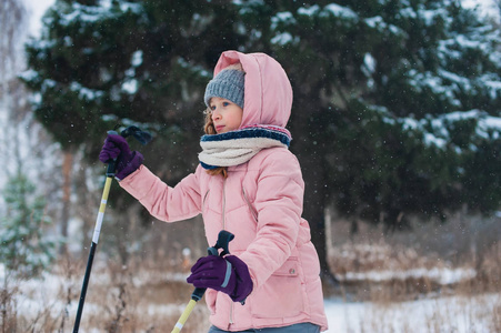 快乐的女孩滑雪在冬天的雪林度假户外。 积极的冬季运动。
