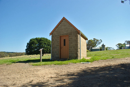 小砖房，绿色草地上有一扇浅棕色的门