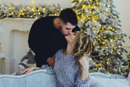 相爱的夫妇一个男人和一个女孩在圣诞树的背景上。 圣诞节背景