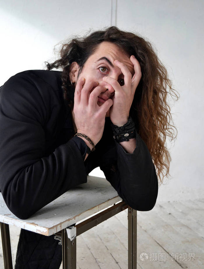 照片肖像表情男演员留着黑色长卷发摆手白色背景