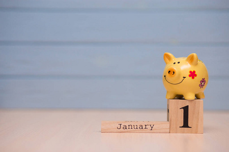 日历日期的财政年度开始,1月1日与储蓄罐的蓝色背景.冬天的时候.