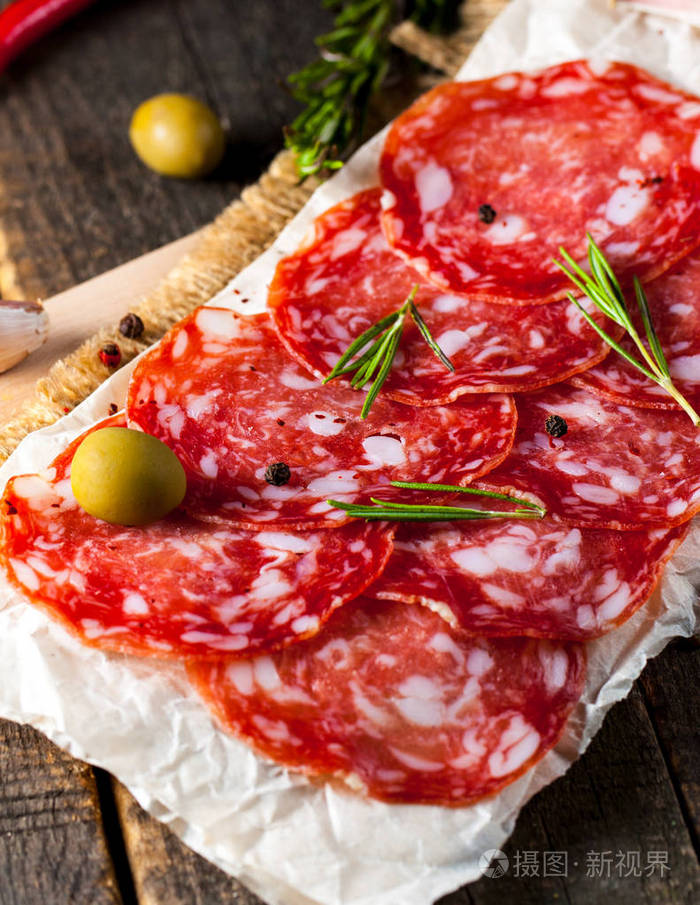 烤肠和腊肠薄切西班牙萨拉米在木材背景上加香料辣椒辣椒辛辣的食物