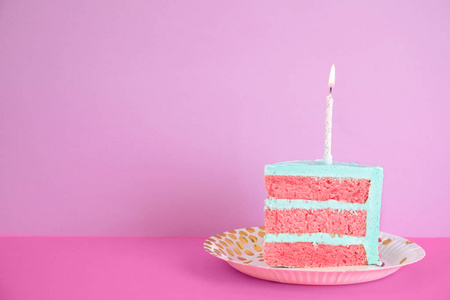 新鲜美味的生日蛋糕切片，桌子上有蜡烛，背景是彩色的。文本空间