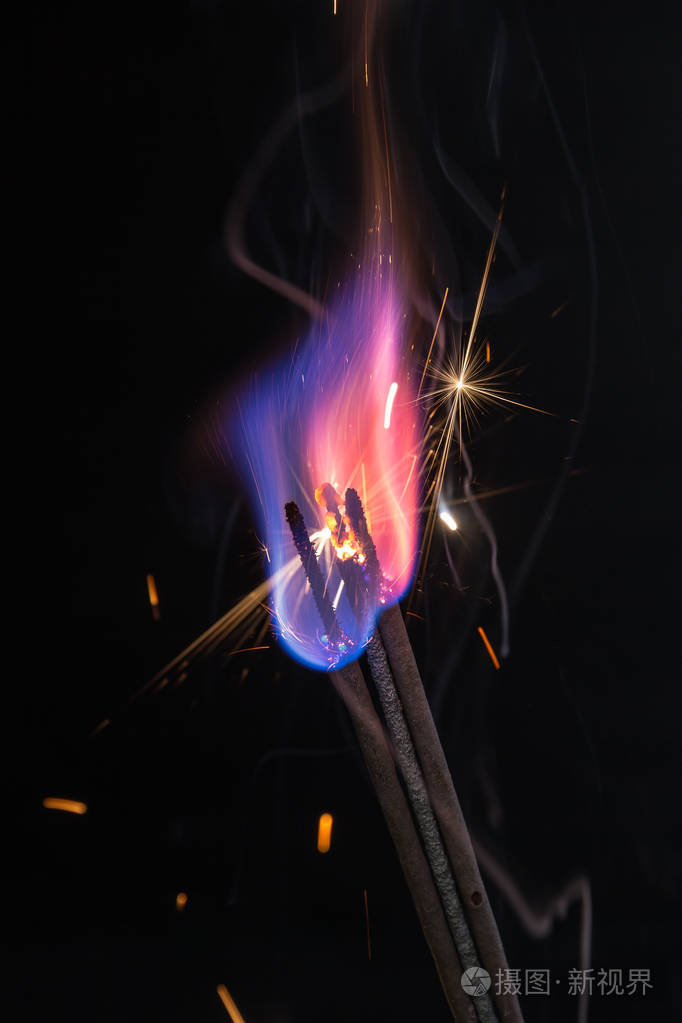 彩色火焰和火花在黑色背景上的特写