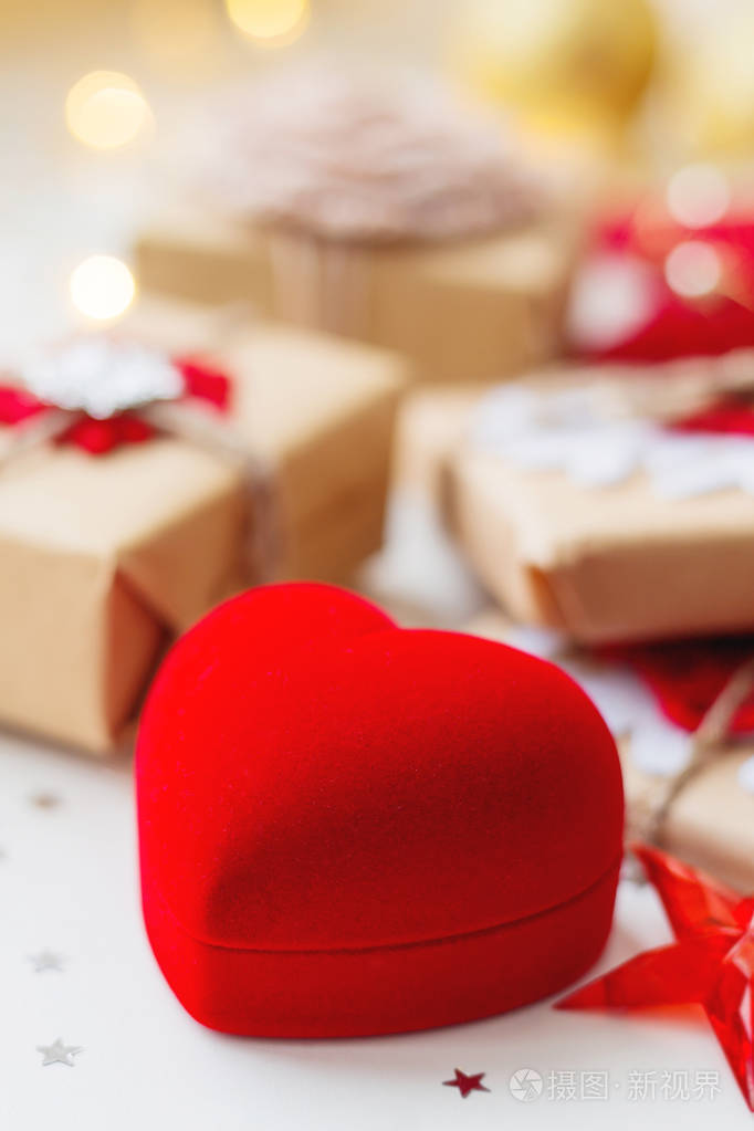 圣诞节和新年背景与红色盒子形状的心脏和礼物装饰圣诞树。 节日背景与星星纸屑和灯泡。 文本的地方。