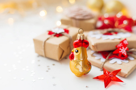 圣诞节和新年背景与公鸡象征2017年圣诞礼物和装饰圣诞树。 节日背景与星星纸屑和灯泡。 文本的地方。