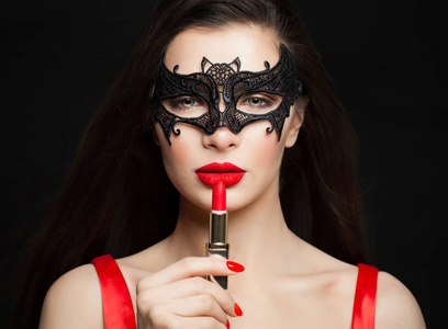 完美的黑发女人，红唇在黑色狂欢节面具。 化妆品及化妆品概念