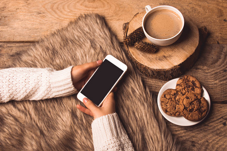 女孩手中的白色手机, 咖啡, 饼干, 圆锥和毛皮照片