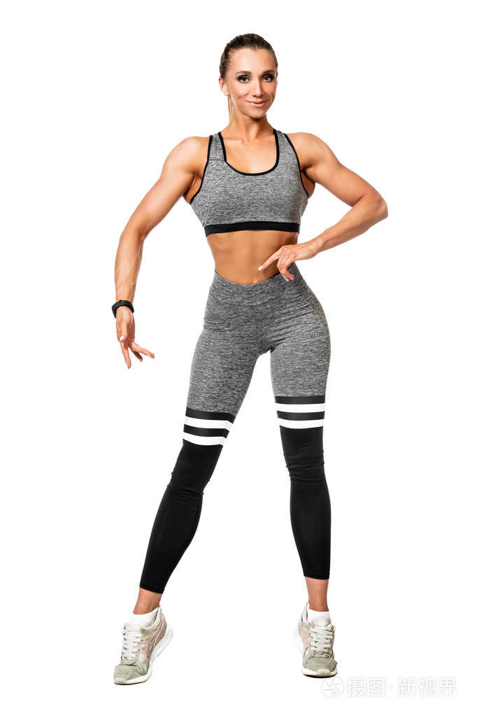 一个运动的年轻女人在白色背景上摆姿势的完整长度肖像.