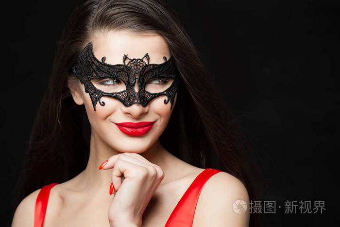 快乐的女人黑色面具的时尚模特微笑在抽象的夜晚闪闪发光的背景