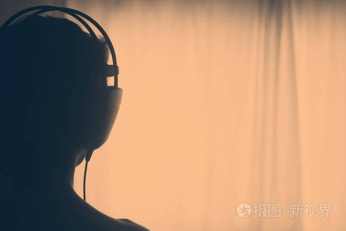 女dj戴杰女士戴着封闭耳机听音乐在艺术照片.