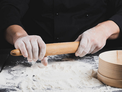 s hands, white wheat flour is poured on the table