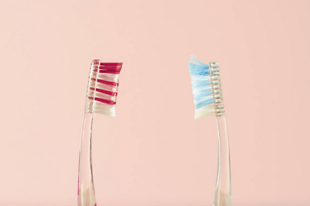 两把牙刷是新的，用在粉红色的背景上。 改变牙刷口腔卫生的概念牙科友好家庭