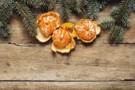 橘子和圣诞树的树枝在木制的背景上。 新年和圣诞节的概念。 平躺式顶部视图