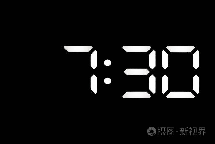 黑色背景上的真正白色led数字时钟显示时间为7:30
