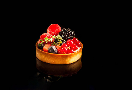 纸杯蛋糕和浆果与反射在黑色背景。食物理念, 丰盛的早餐。2019年的颜色