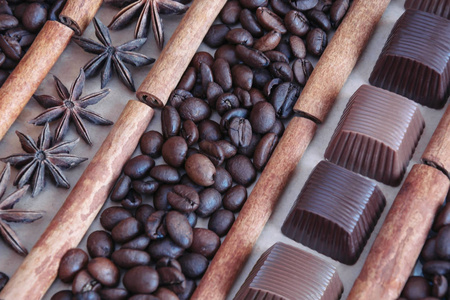 咖啡豆背景与巧克力八角星和肉桂棒。