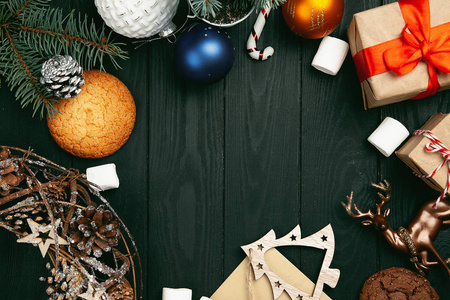 木制桌子上带有圣诞装饰的空地的顶部视图。 顶部的空树皮与小礼物，现在新年装饰树枝的树木。 复制空间