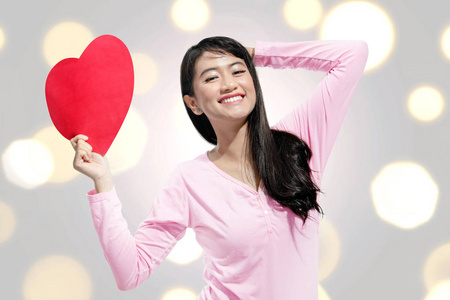 可爱的亚洲女人手上拿着红色的心纸。 情人节