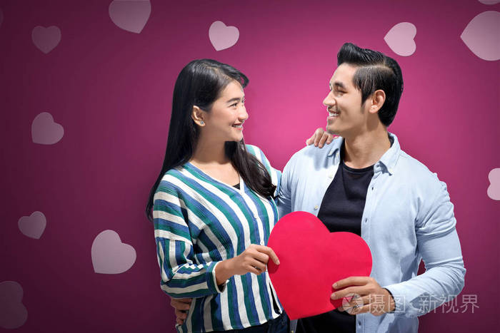 浪漫的亚洲夫妇相爱,抱着红心. 爱情观念和情人节