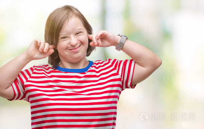 患有唐氏综合症的年轻成年妇女用手指捂住耳朵照片-正版商用图片15w