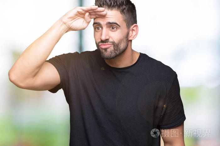 年轻英俊的男子越过孤立的背景,非常高兴和微笑,看着遥远的手托头.