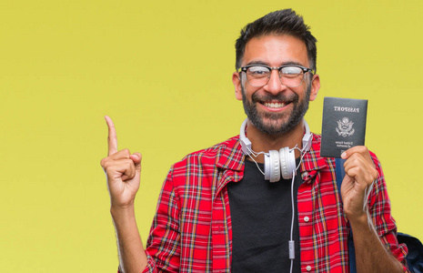 成年西班牙裔学生男子持美国护照在孤立的背景下非常高兴地用手和手指指向一边