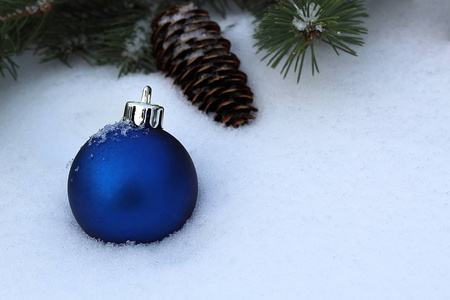 蓝色圆形圣诞树玩具躺在白色的雪地上